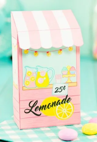 Custom-printed gable shaped lemonade stand box with pastel pink wood-texture design, striped canopy top, and illustrated pitchers, desserts, and lemon graphics; playful branding and 25¢ price tag evoke vintage summer vibes