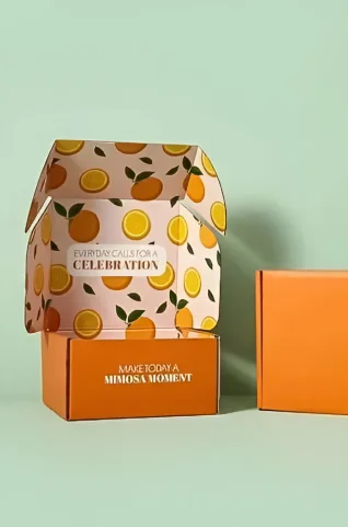 Custom orange influencer boxes with playful interior orange-slice design, featuring uplifting messages “Everyday calls for a celebration” and “Make today a mimosa moment.”