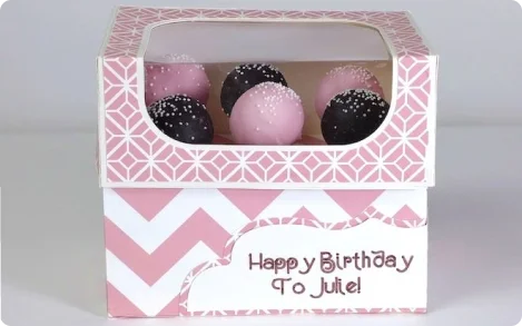 tuck top cake pop box with die-cut PVC window at top panel and custom printing of tagline on front and texture in pink and white on entire surface